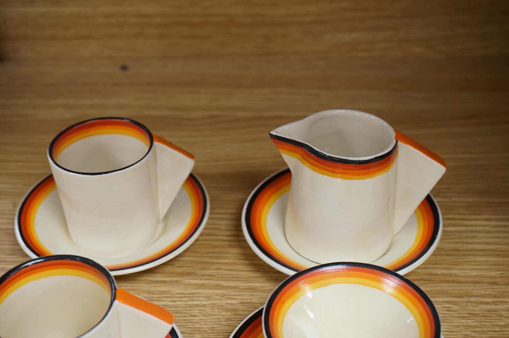 An Art Deco Clarice Cliff Bizarre part coffee set and a similar Rhodanthe-pattern preserve pot and cover, largest 11cm high